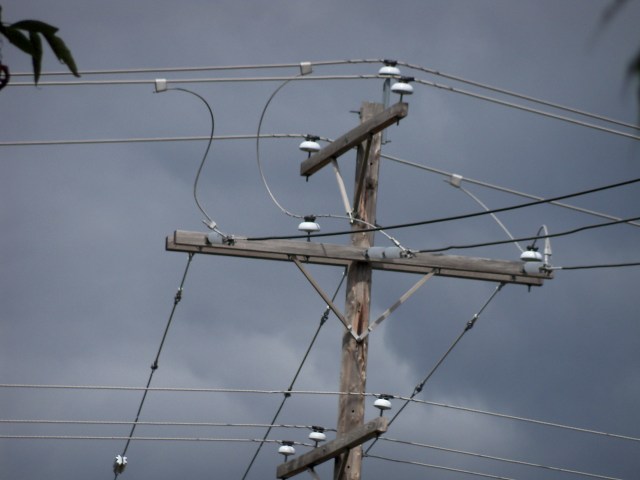porcelain insulators against dark clouds