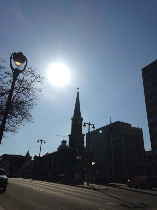 church steeple silhouetted against bright sun