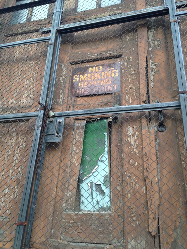 No smoking sign behind locked fencing