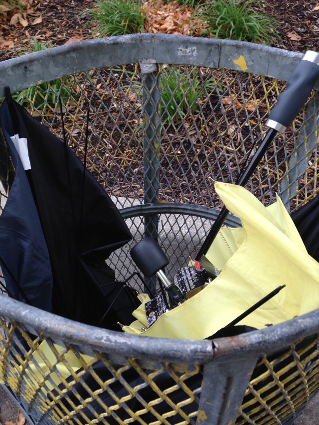 wrecked umbrellas in trash can