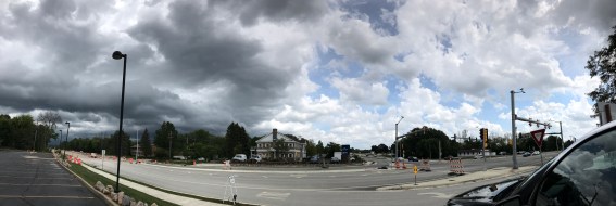 storm clouds meet a sunny blue sky filled with white fluffy clouds