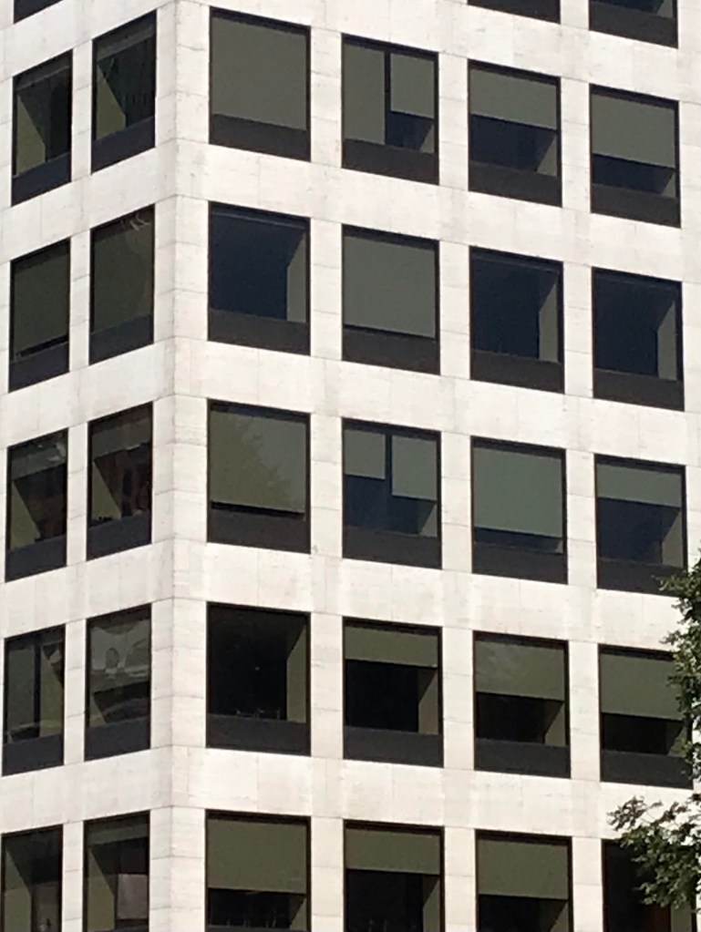 Office building with window shades drawn to various lengths