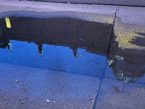 Grohmann Museum reflected in a puddle in the late evening