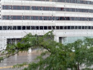 Office window streaked with raindrops