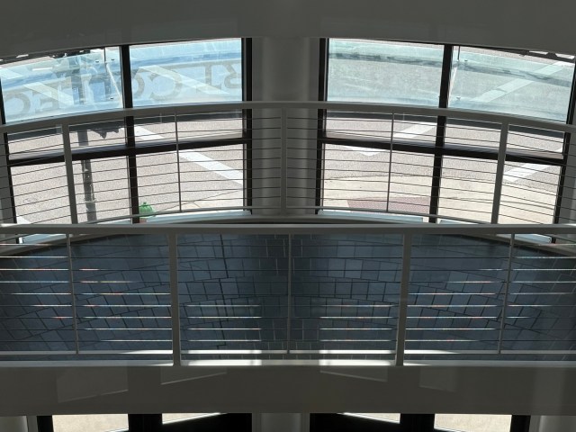 Two windows and an arch of light create a "smiley face" effect on an open staircase.