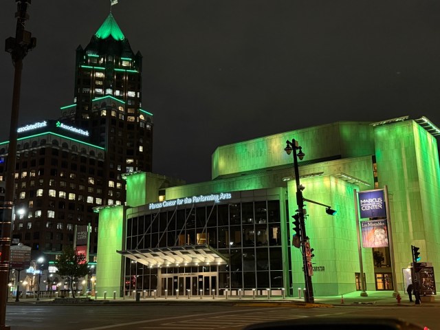 Associated Bank River Center and Marcus Center for the Performing Arts buildings in downtown Milwaukee, illuminated with green lights