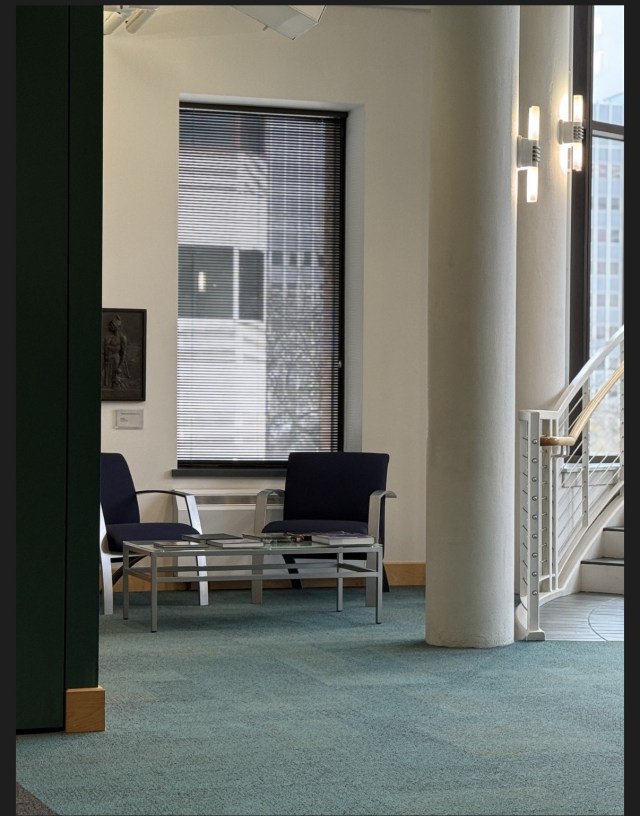 A grouping of chairs near a window in an open, light-filled area of a museum atrium