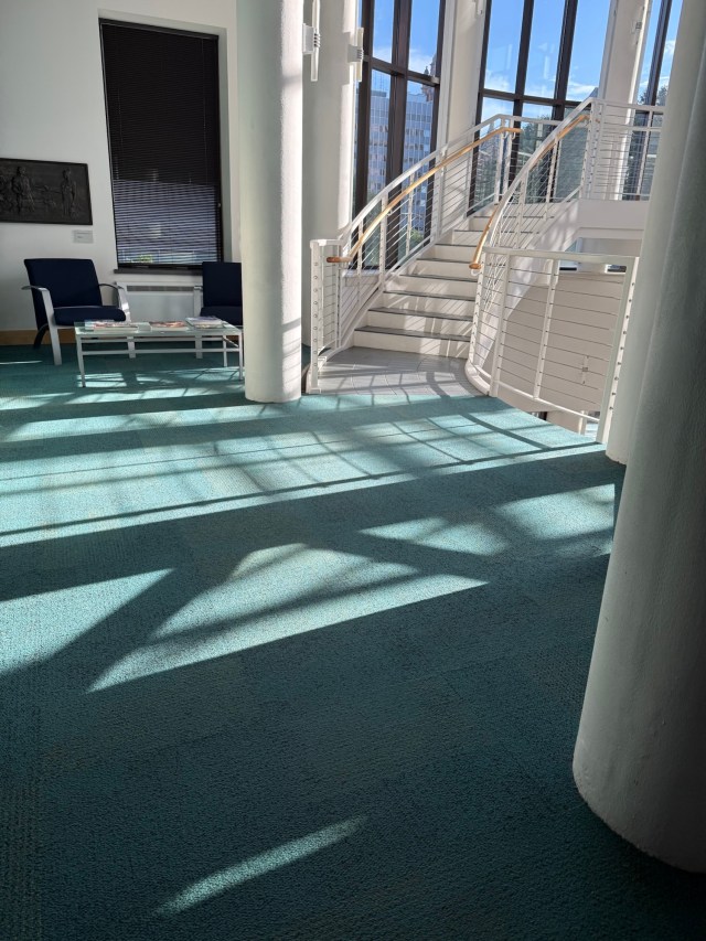 Patterns of light and shadow cast by the sun on the floor near the atrium staircase at the Grohmann Museum